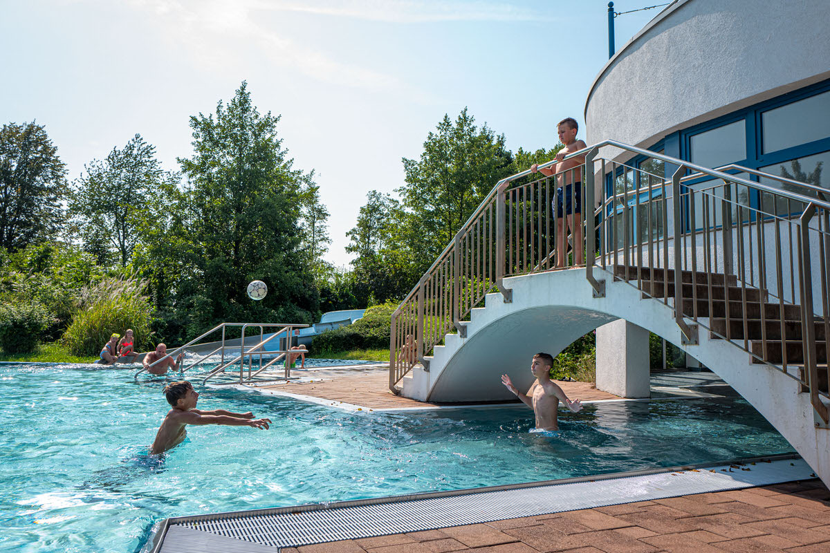 Becken mit ballspielende Jungs und einer Brücke