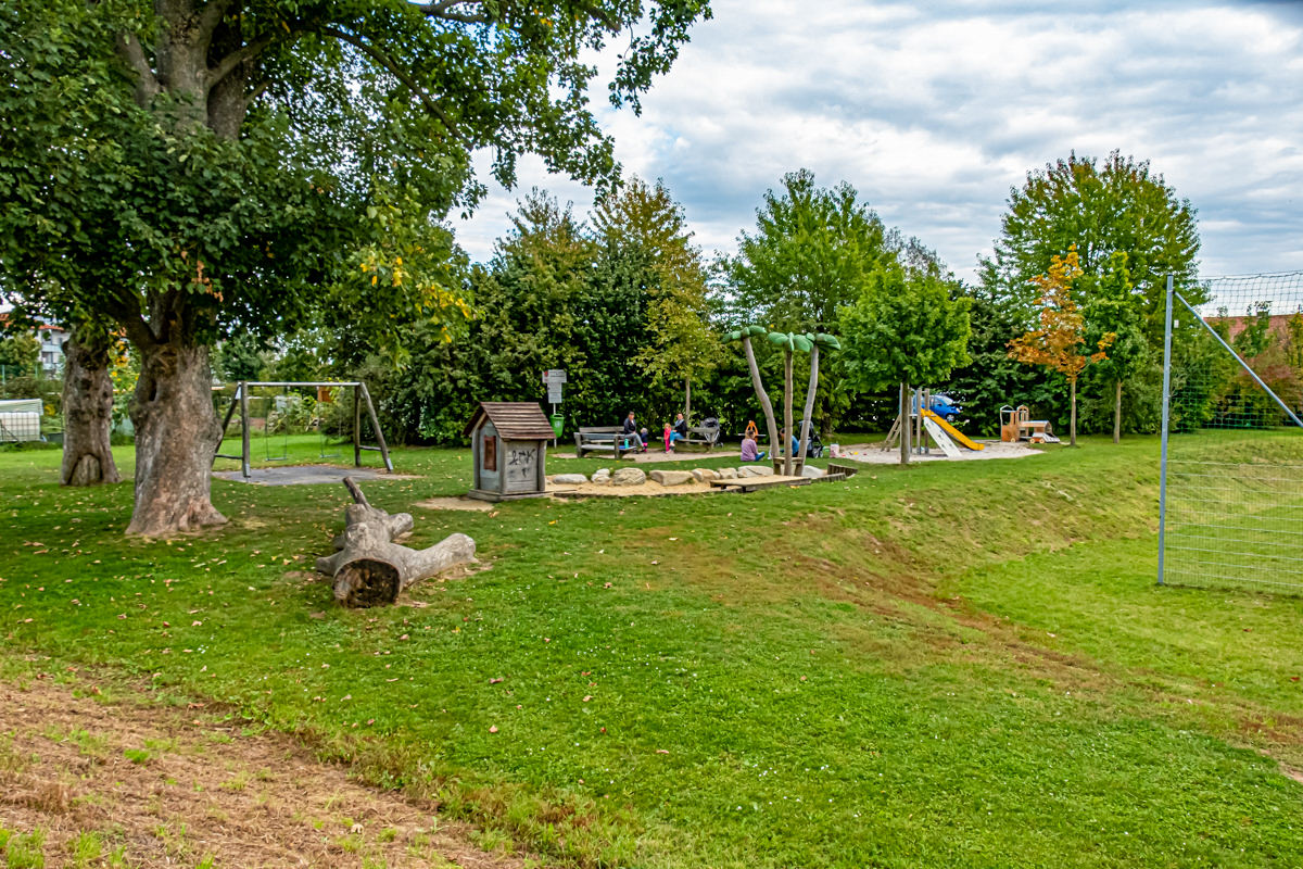 Wiese mit Sandkiste, Rutsche und Hütte