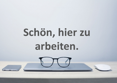 Zugeklappter Laptop mit Brille, links Smartphone, rechts Maus