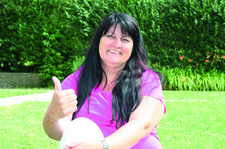 Ilona Rose sitzt in der Wiese und zeigt mit einem Daumen nach oben