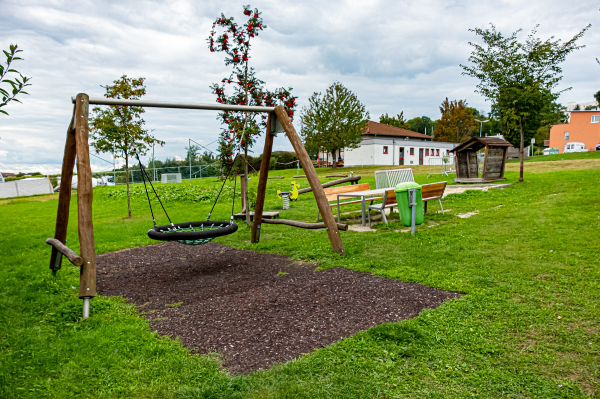 Wiese mit Schaukelplatz und einem Tisch mit Bänken