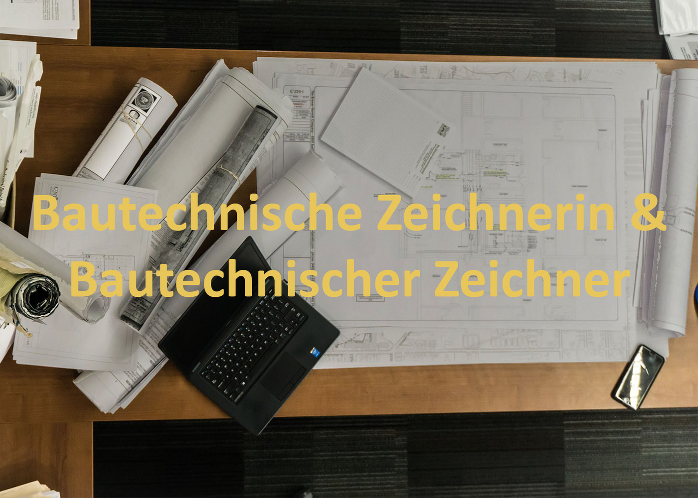 Arbeitsplatz mit Plänen und Laptop