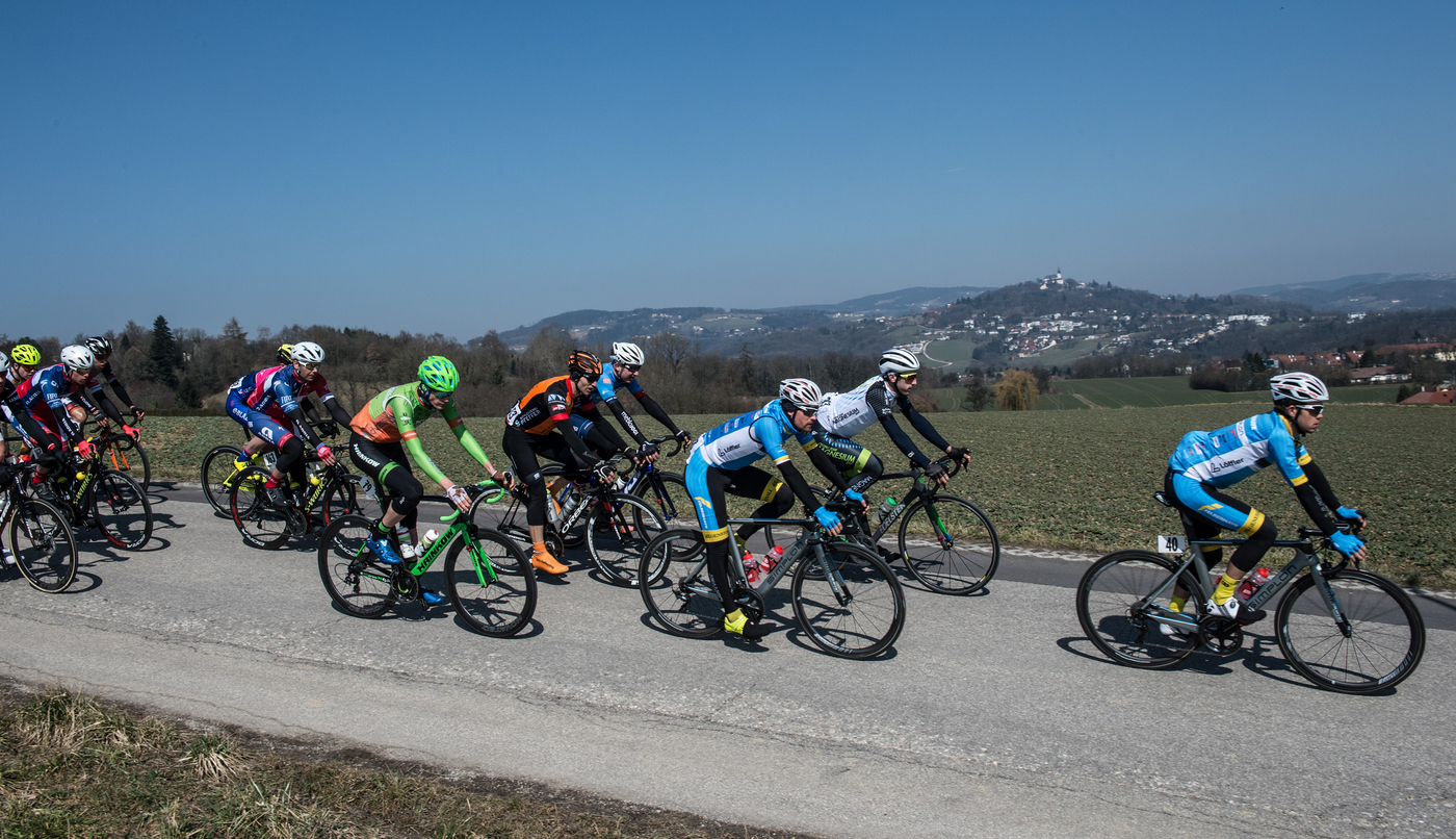 Gruppe von Radfahrern auf Straße, Hintergrund Berge