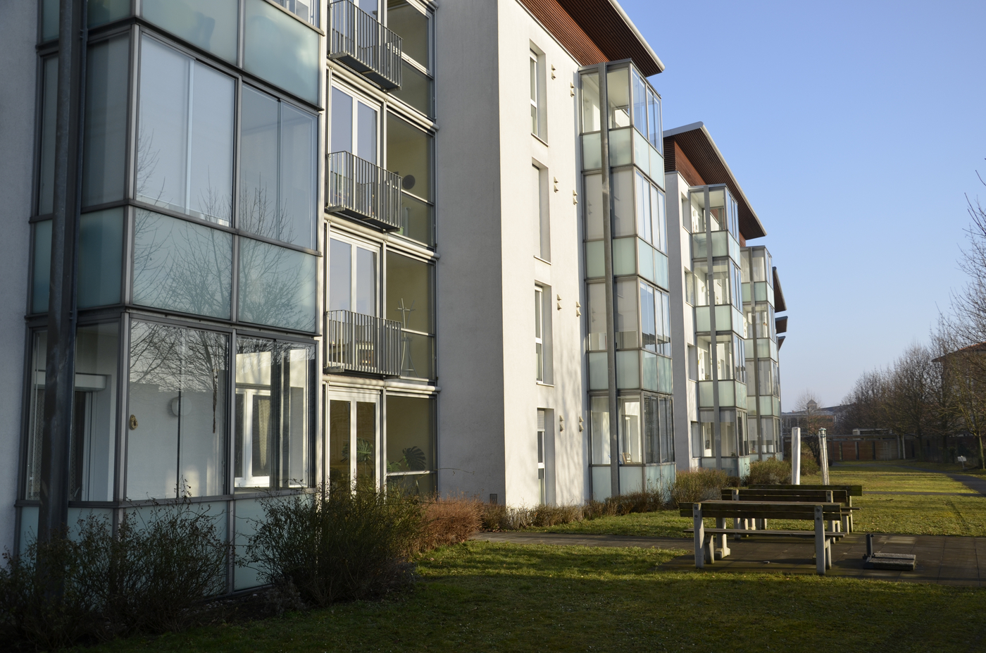 Weißer Wohnblock mit Glasbalkonen